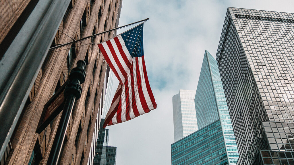 Bandiera americana che sventola con grattacieli sullo sfondo